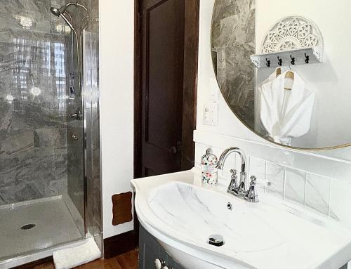 a white bathroom with a sink and a mirror at Royal Hotel Sydney in Sydney