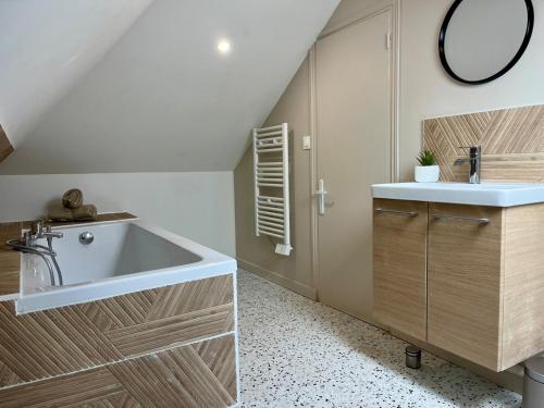 une salle de bain avec un lavabo et une baignoire dans l'établissement Le Jasmin, à Rouen