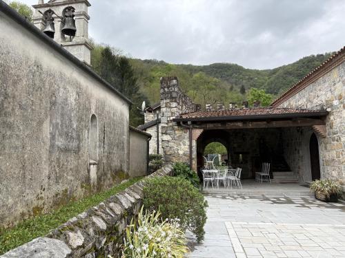 an old stone building with a patio with tables and chairs at Incantevole rifugio nel castello di Ahrensperg in Pulfero