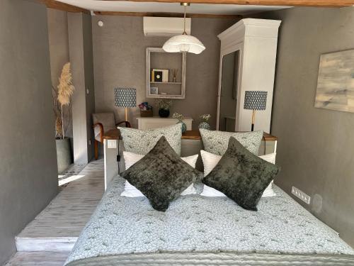 une chambre avec un lit avec des oreillers dessus dans l'établissement Le Maskalou, à La Colle-sur-Loup