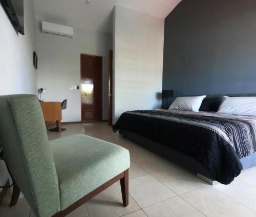 a bedroom with a bed and a chair at Villa Ángeles - Elegancia en la Zona Hotelera in Cancún