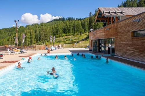 un groupe de personnes nageant dans une piscine dans l'établissement Appartement au pied des pistes, à Puy-Saint-Vincent