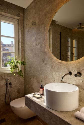 a bathroom with a white sink and a mirror at The Calliston in Corfu Town