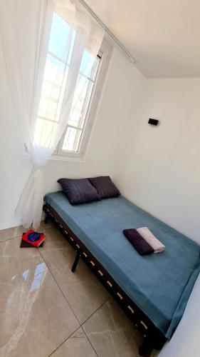 un lit dans une chambre avec une fenêtre dans l'établissement Nouveau appartement carré d'or, à Nice