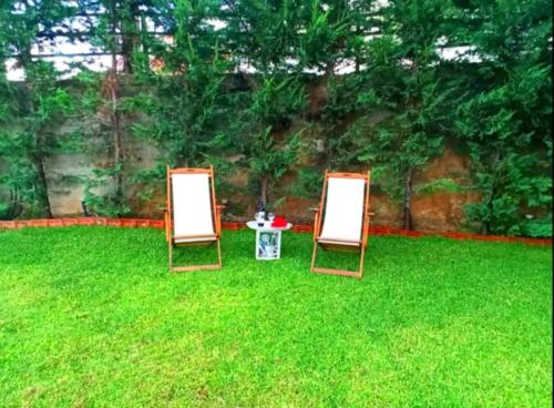 two chairs sitting in the grass in a yard at VE Apartment in Khelmáta