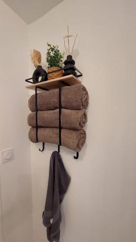 a pile of towels on a shelf on a wall at Le Réverbère, appartement de vacances in Lectoure