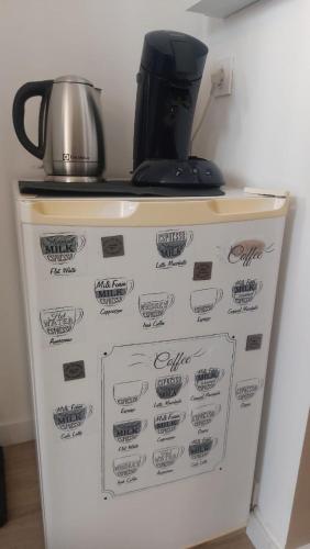 a refrigerator with a coffee pot on top of it at Le Réverbère, appartement de vacances in Lectoure