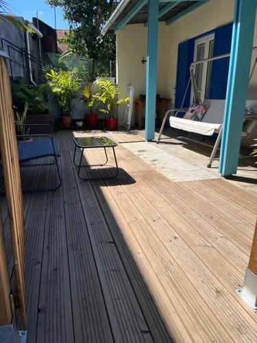 a wooden deck with a bench on a house at Douceur du Sud in Le Tampon