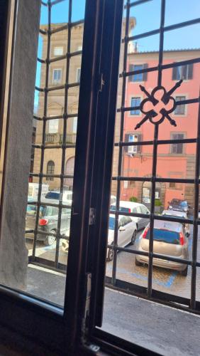a window with a view of a parking lot with cars at La Dimora di GI in Viterbo