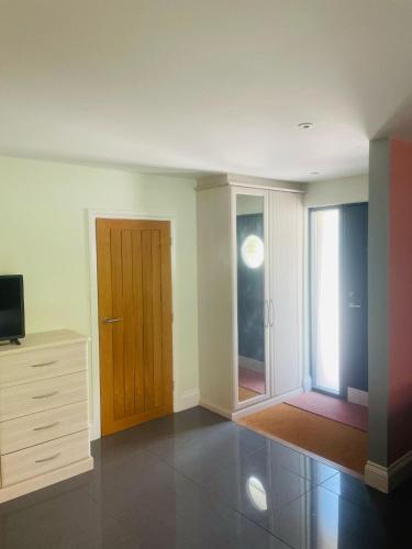 an empty living room with a door and a television at The Apartment at Estuary Escapes in Kingsbridge