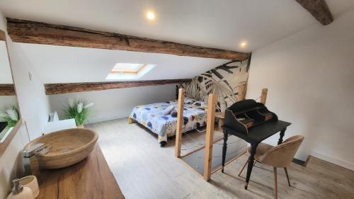 - une chambre mansardée avec un lit et un piano dans l'établissement Joli appartement meublé tout équipé, à Béziers