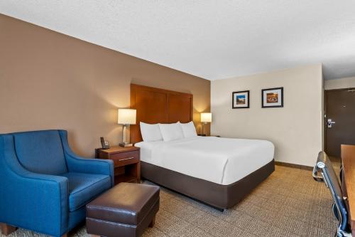 a hotel room with a bed and a blue chair at Comfort Inn Santa Rosa on Route 66 in Santa Rosa