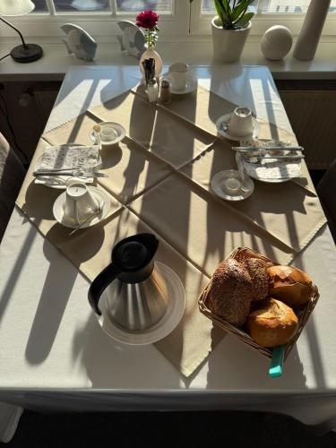 een tafel met een bord brood en een waterkoker bij Frühstückspension Haus Friederike in Dangast