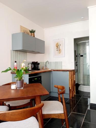 une petite cuisine avec une table et des chaises en bois dans l'établissement Cocon convivial a mommartre, à Paris
