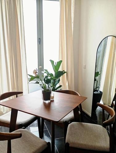 une table en bois avec une plante en pot dans l'établissement Cocon convivial a mommartre, à Paris