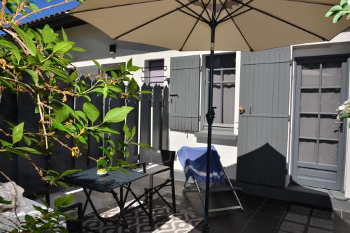 an umbrella and a table and chairs on a patio at La Villa du Grand Large in Biscarrosse