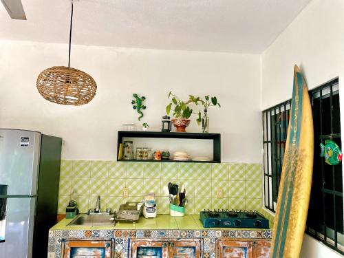 a kitchen with a sink and a counter with a surfboard at Green Studio at Casa Cacao with Terrace and Starlink in Brisas de Zicatela