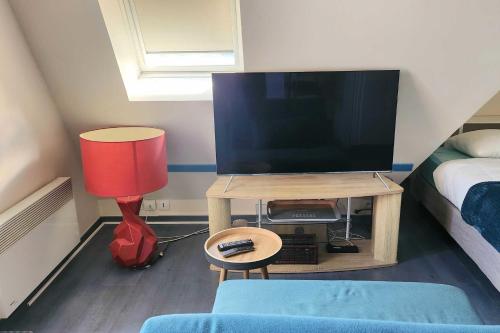 Cette chambre dispose d'une télévision et d'une table avec une lampe. dans l'établissement Studio for two with balcony of 20 m2 - Cabourg, à Cabourg