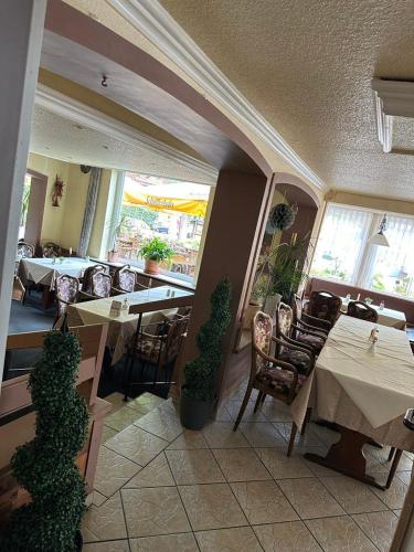 a dining room with tables and chairs in a restaurant at Hotel-Café-Restaurant Parkhaus in Altenau