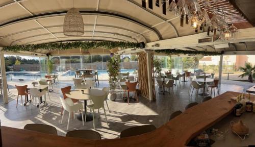 un restaurant avec des tables et des chaises ainsi qu'une piscine dans l'établissement Alizo, à Lecci