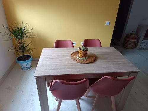 a wooden table with pink chairs and a cupcake on it at Apartamento La Bella Vista ATBA00361 in Zafra