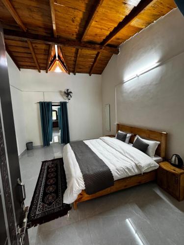a bedroom with a large bed with a wooden ceiling at Nal Damyanti Homestay in Bhīm Tāl