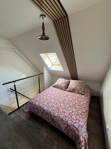 a attic bedroom with a bed and a window at Maison proche de la mer in Le Crotoy