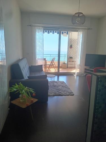 a living room with a couch and a view of the ocean at Vista dall' Eden in Mortola Superiore
