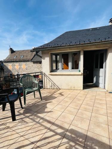 a patio with a green bench and a house at Chez Routcho in Saint-Sauveur-de-Peyre