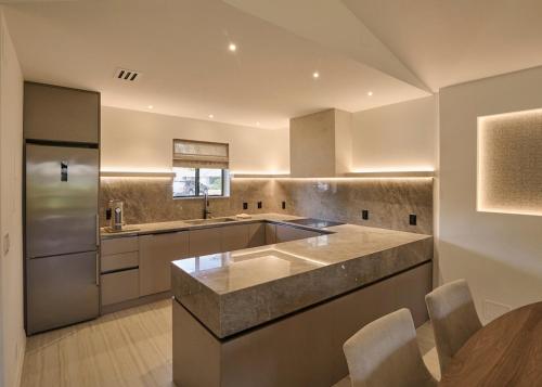 a kitchen with a stainless steel refrigerator and a table at The Edwardian at PGA, designer's Cottage in Palm Beach Gardens