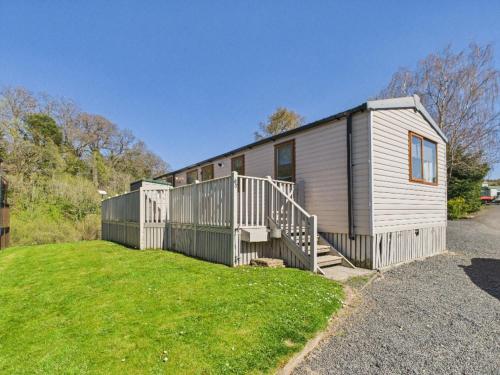 a tiny house with a staircase in a yard at Riverside Lodge in Hawick