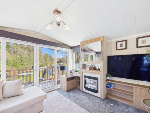 a living room with a television and a fireplace at Riverside Lodge in Hawick