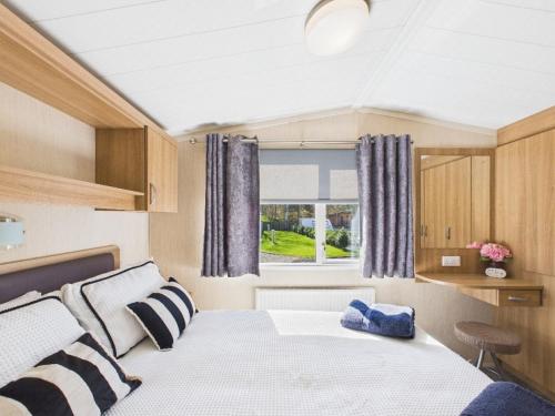 a small room with a bed and a window at Riverside Lodge in Hawick