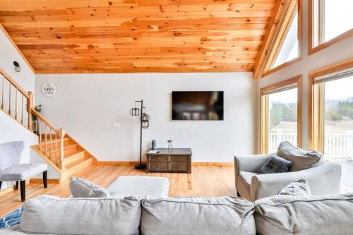 a living room with a couch and a tv at Lakeside Catskills Escape - Soak, Sip, Stargaze in Cairo