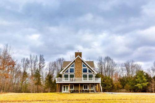 a large house sitting on top of a field at Lakeside Catskills Escape - Soak, Sip, Stargaze in Cairo