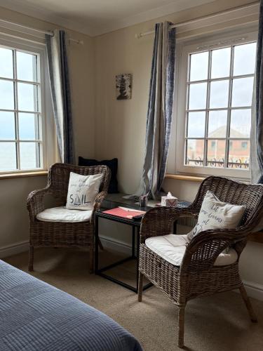 a bedroom with two chairs and a table and windows at The Old Brewhouse in Arbroath