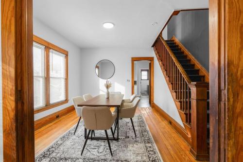 a dining room with a table and chairs and a staircase at Grand Rapids Gem - Near Heart of DT - Sleeps 10 in Grand Rapids