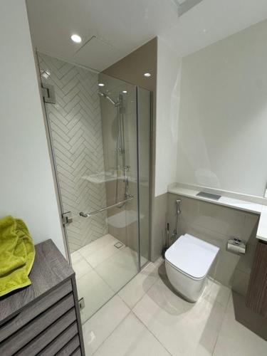 un baño con inodoro y ducha de cristal en Cozy beautiful studio, en Sharjah