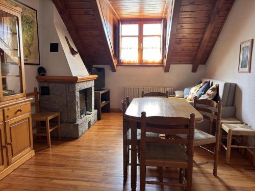 a living room with a table and a fireplace at BPirineos-Senarta in Benasque