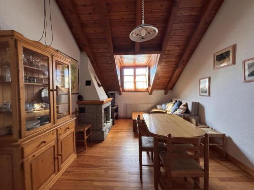 a kitchen and dining room with a table and a wooden ceiling at BPirineos-Senarta in Benasque