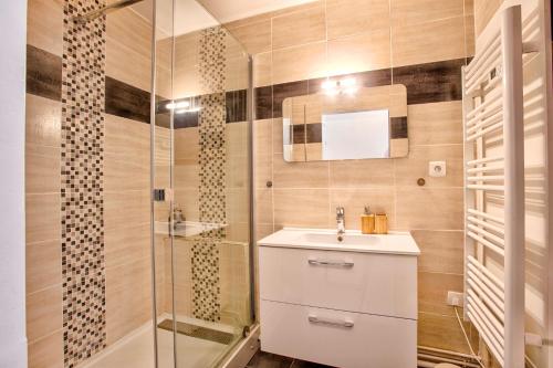 une salle de bain avec un lavabo et une douche dans l'établissement La Frégate Piscine Terrasse Centre ville, à Trouville-sur-Mer