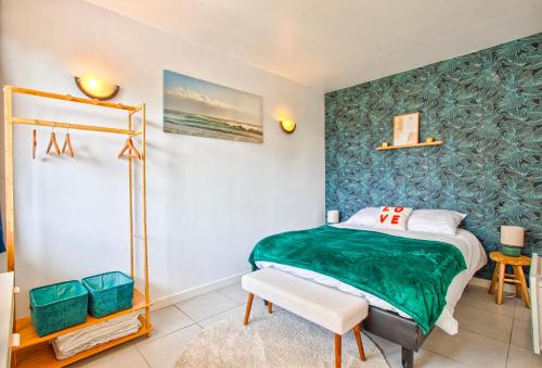 une chambre avec un lit avec une couverture verte dans l'établissement La Frégate Piscine Terrasse Centre ville, à Trouville-sur-Mer