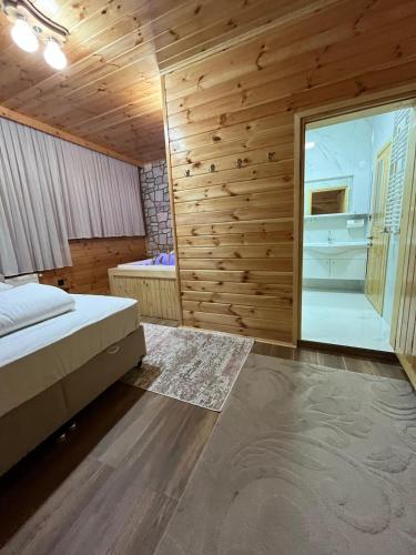 a bedroom with a bed and a large window at Defne Apart in Çamlıhemşin
