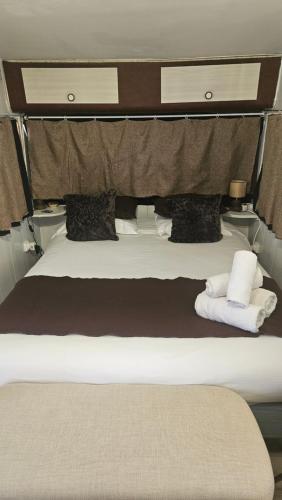 a large bed with two pillows on top of it at Esprit Etape in Saint-Barthélemy-de-Vals