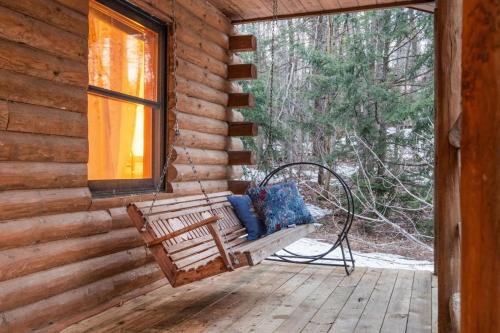 a bench on a porch of a log cabin at Lucky Log Cabin Hottub fireplace 12min to Mt Snow in Wardsboro