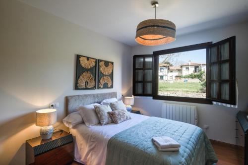 a bedroom with a bed and a large window at Casa vacacional La Casa de Otto in Llanes