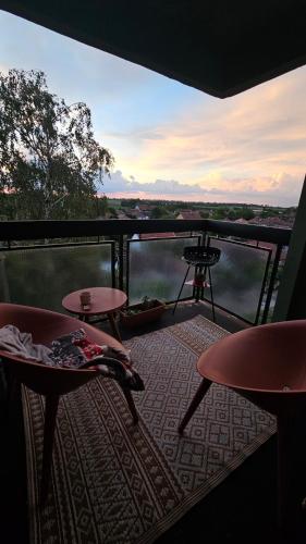 a balcony with two tables and a view of the water at TESLA Creative Space in Odžaci
