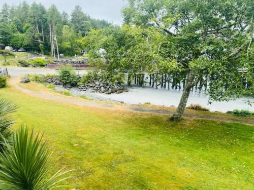 a park with a tree in the grass at Tofino Eco Waterfront Condo in Tofino