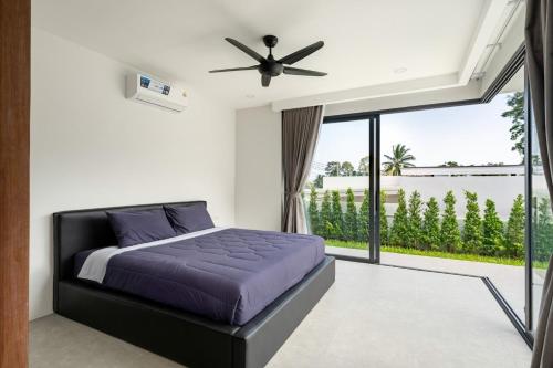 a bedroom with a bed and a large window at Villa Sabai Lamai in Ban Thung