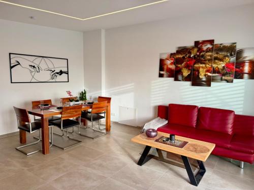 een woonkamer met een rode bank en een tafel bij Mc Home Neues und sonniges Doppelhaus, Top 1 mit grosse Terrasse und E-Ladestation in Dobl bei Graz in Dobl